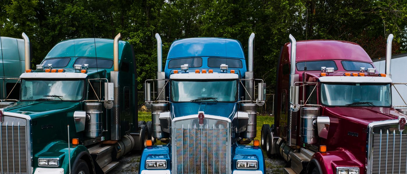 A row of polished tractor units parked in a yard